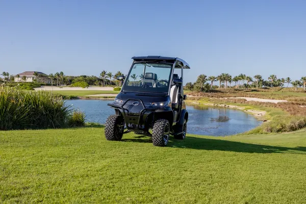 Sleek black D3 Lifted golf cart from Luxury Electric, perfectly blending style and performance with a breathtaking scenic backdrop.