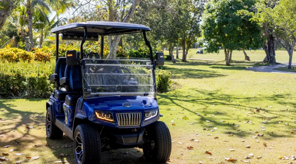 Carritos de golf eléctricos en color azul recorriendo espacios verdes, perfectos para campos de golf o comunidades residenciales.