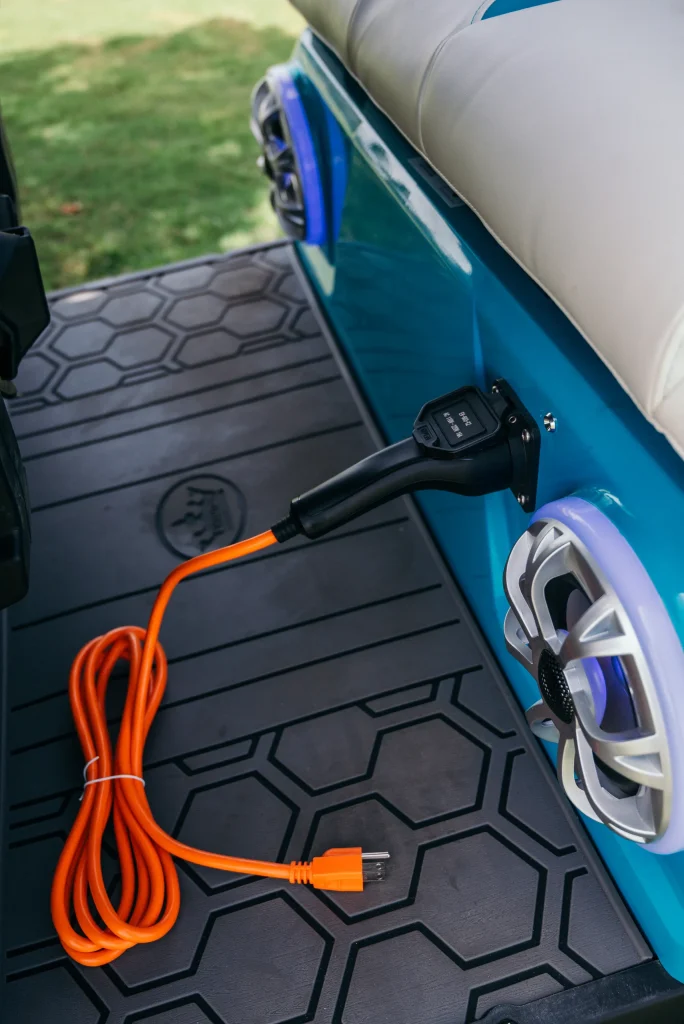 Un carrito de golf cargándose, demostrando las ventajas de elegir un carro de golf eléctrico vs golf de gasolina