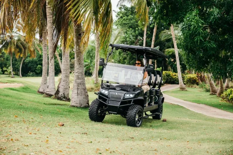 Mujer conduciendo carritos de golf en un campo, disfrutando un recorrido cómodo, seguro y agradable durante todo el trayecto.