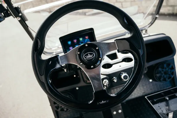 Golf cart ambulance con acabados resistentes, sistema eléctrico eficiente, mostrando la parte del volante y pantalla digital.